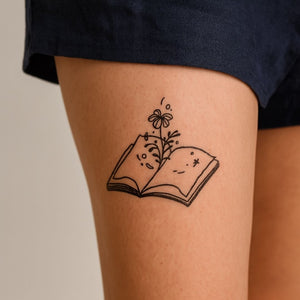 Fine line flower growing from an open book temporary tattoo - 1 | Temporalis